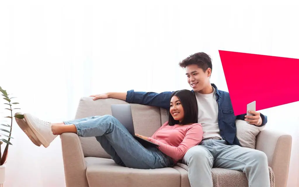 Jeune couple heureux assis sur un canapé